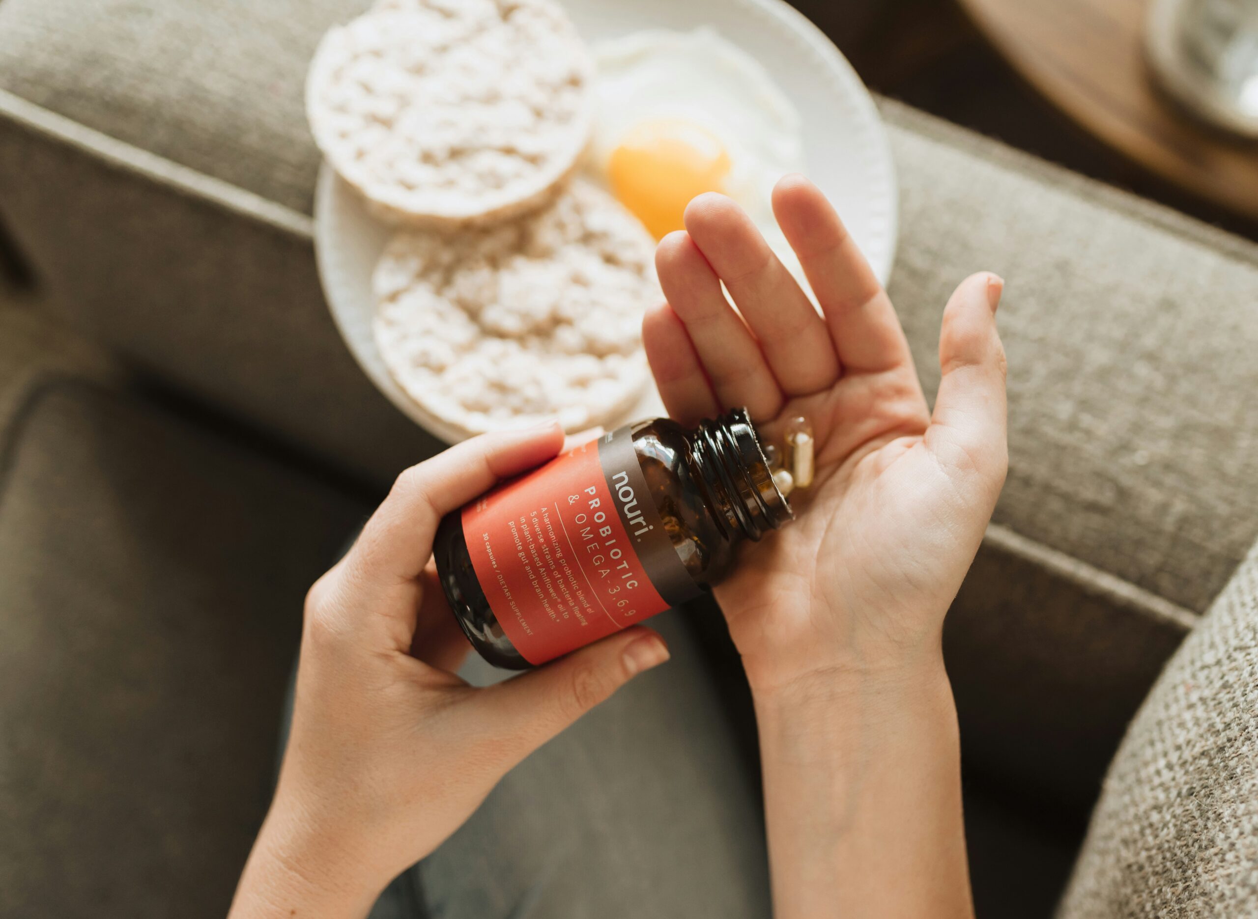 Hands holding a supplement bottle while reading the facts label closely