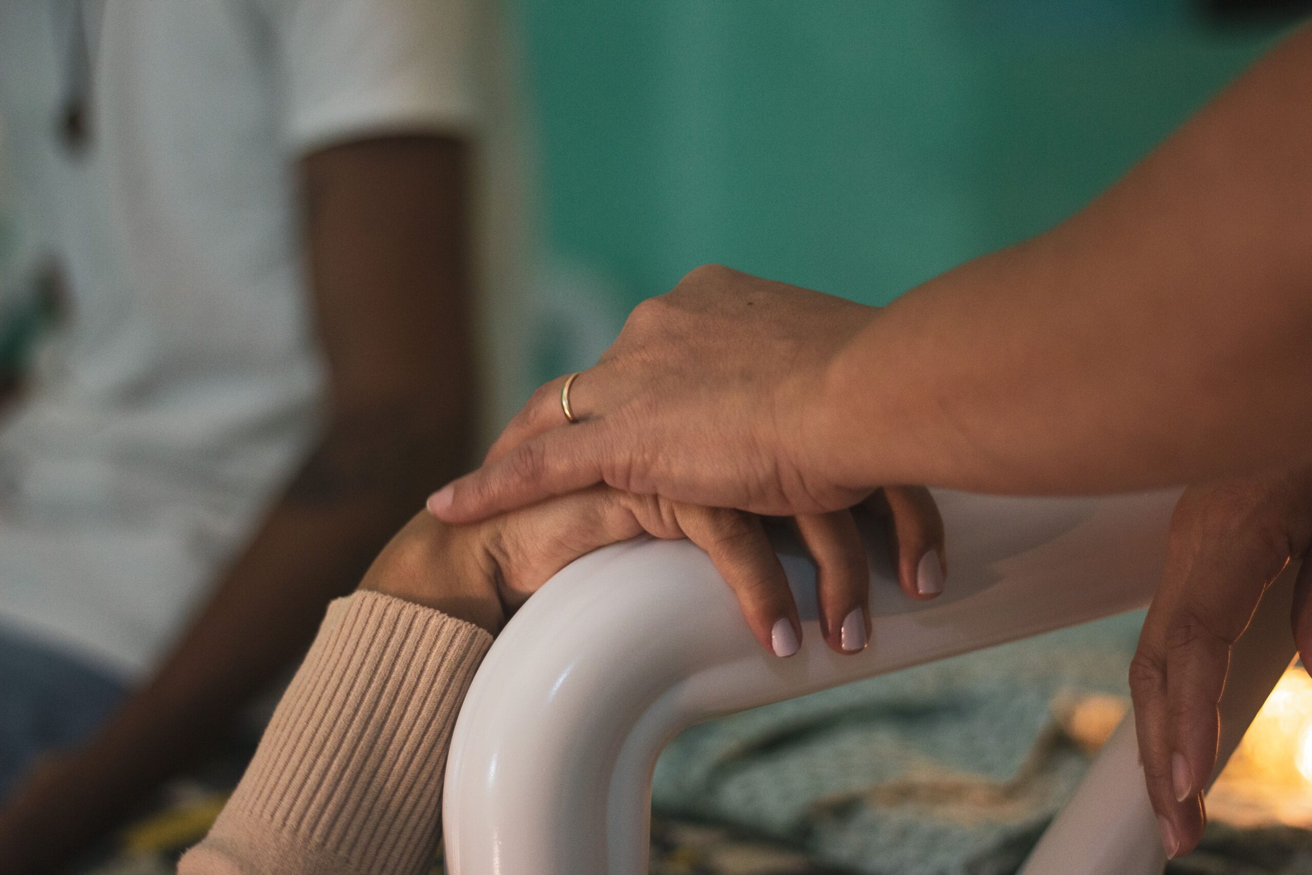 Close-up of comforting hands touching in a hospital room