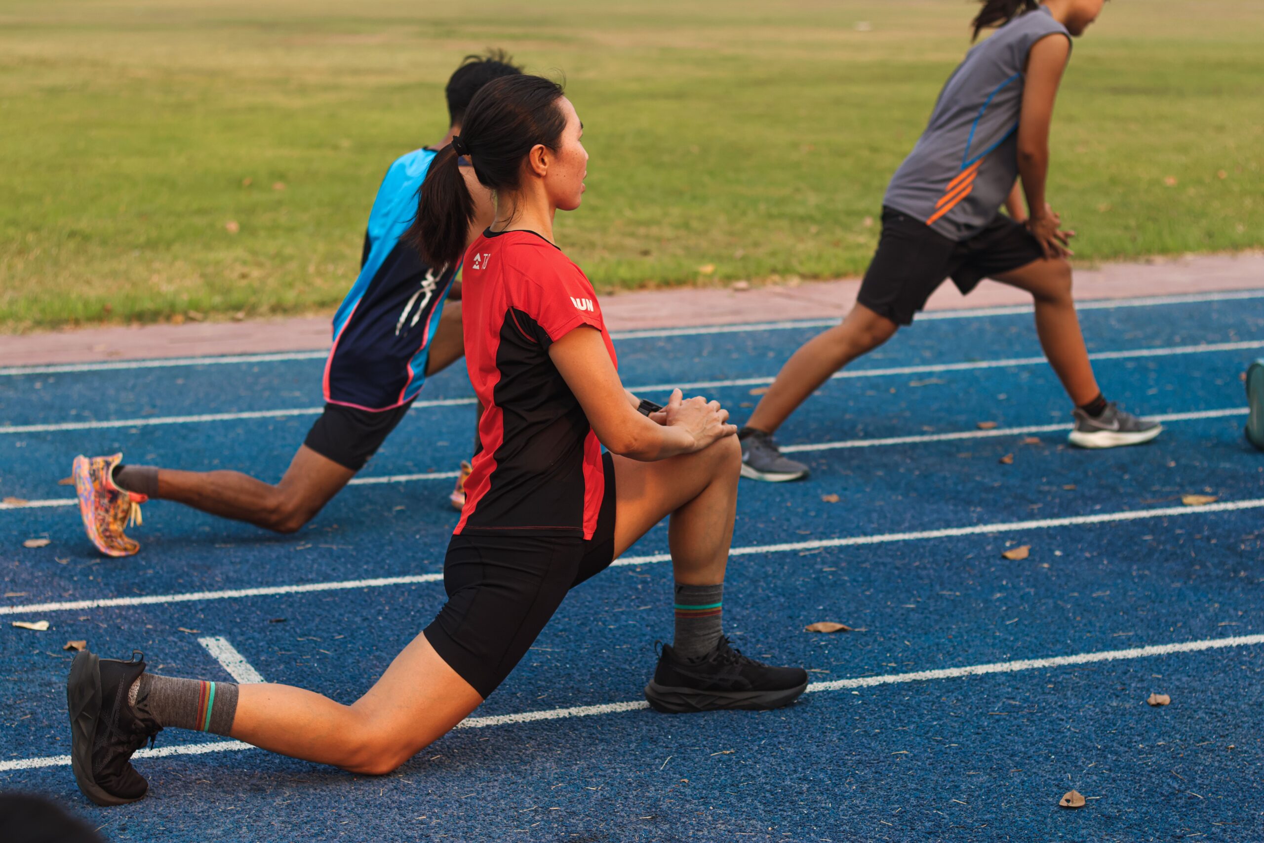 Group of athletes warming up on a track field