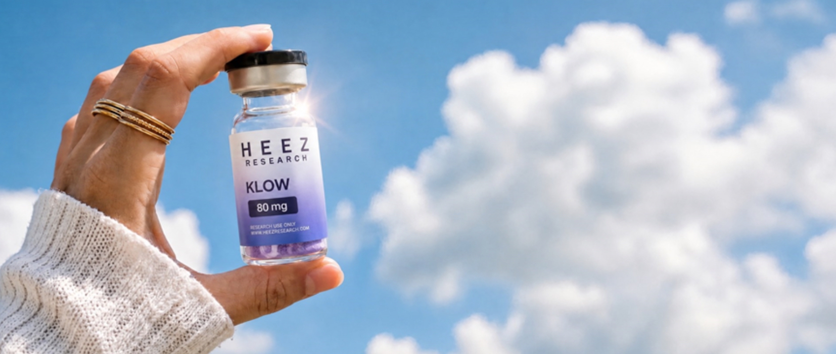 HEEZ Research KLOW 80 mg research vial held against a blue sky